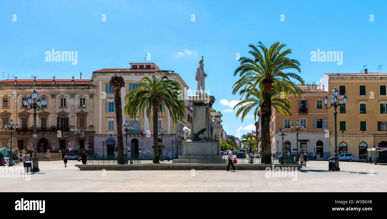Square in an Italian smalltown with historical buildings, staue, palm trees. Bright summer day. Stock Photo