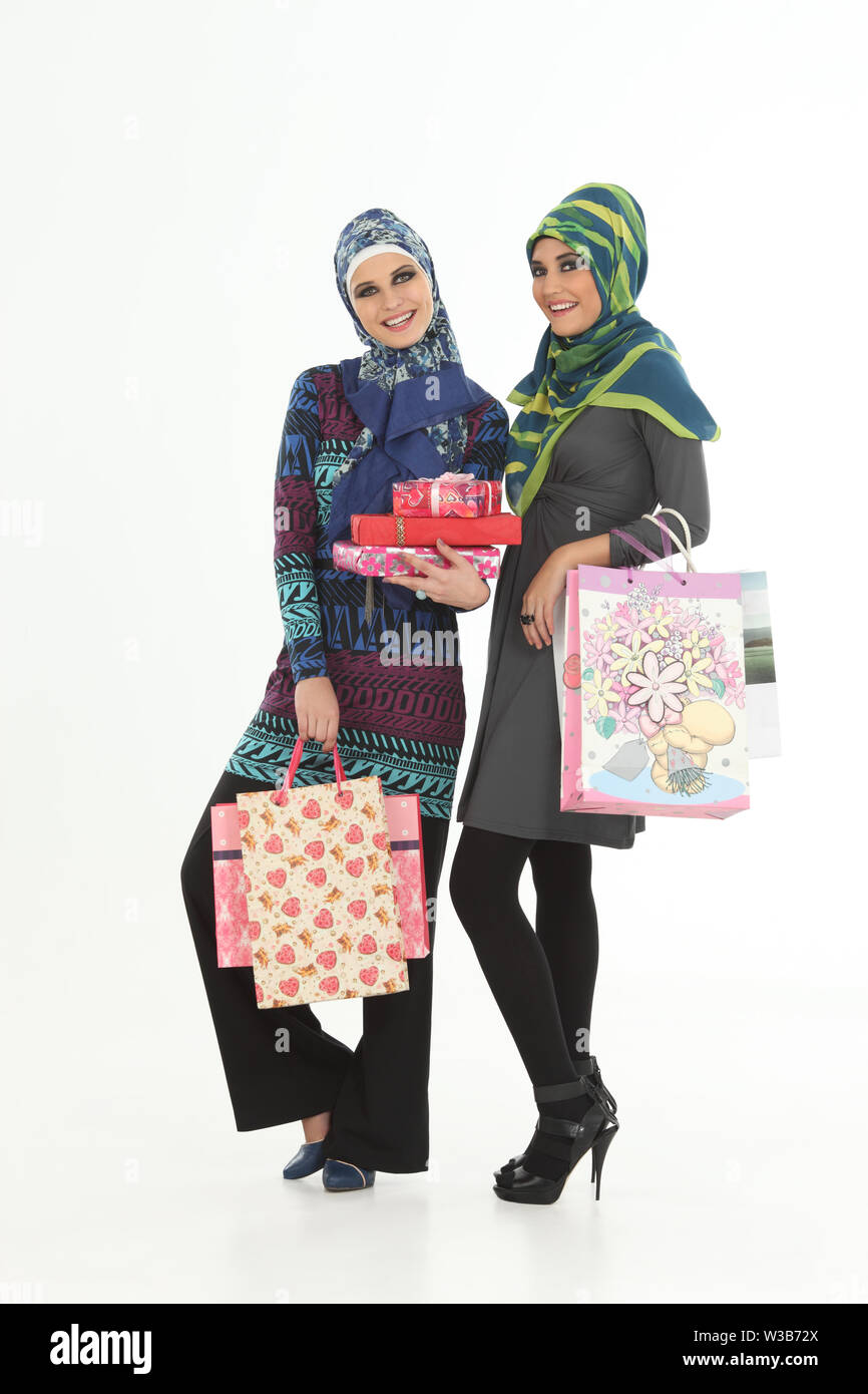 Two women carrying shopping bags and smiling Stock Photo