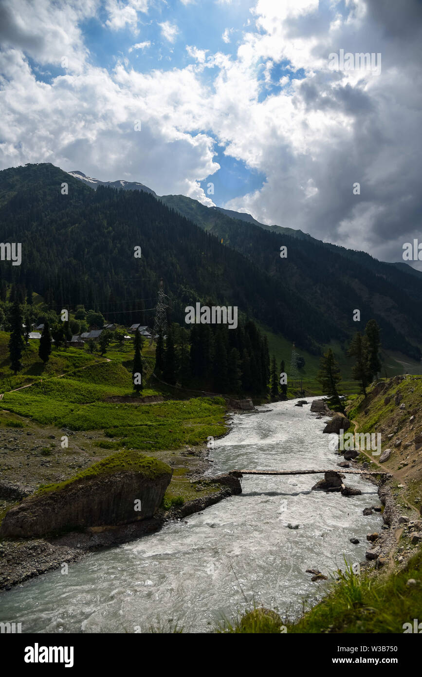 Ganderbal, Jammu and Kashmir, India. 13th July, 2019. River Sindh flowers under the foothill of Himalayan mountains during a cloudy evening in Sonamarg, some 85kms from summer capital Srinagar.Jammu and Kashmir is a disputed territory divided between India and Pakistan but claimed in its entirety by both sides. Credit: Idrees Abbas/SOPA Images/ZUMA Wire/Alamy Live News Stock Photo