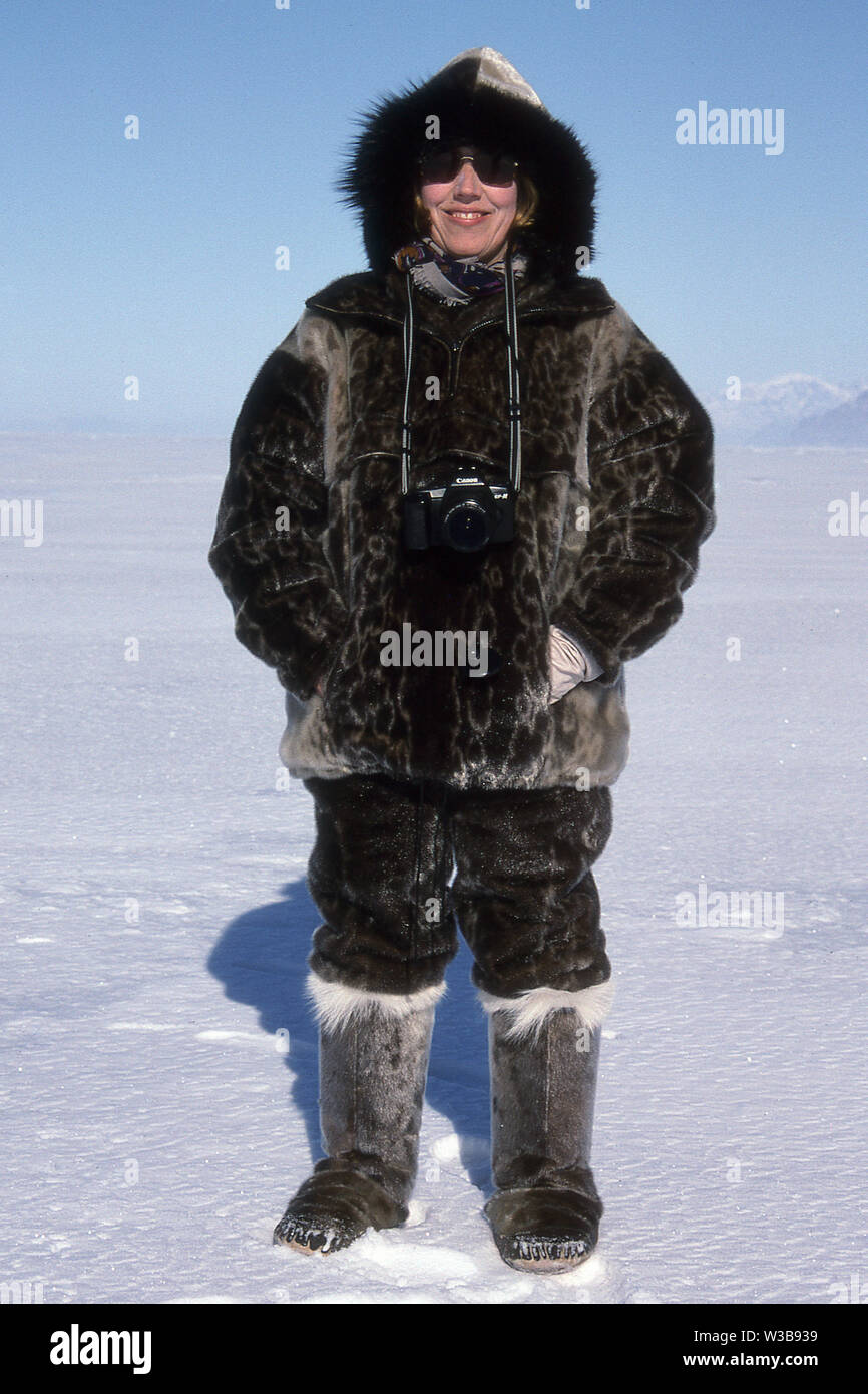 TOURIST IN SEALSKIN OUTFIT FOR DOG SLED RIDE ON THE FROZEN SEA ICE IN GREENLAND. Stock Photo