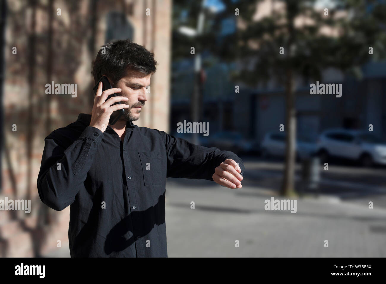 Young man making phone call walking on the street . Stock Photo