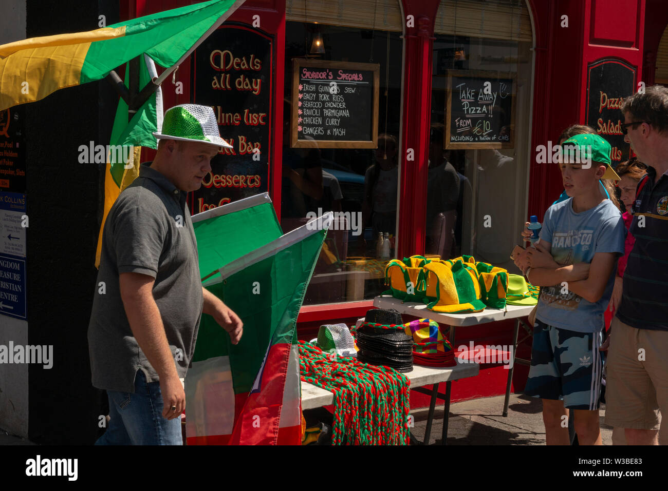 Street vendor selling Kerry flags and hand bands memorabilia on a matchday in Killarney, County Kerry, Ireland. Stock Photo