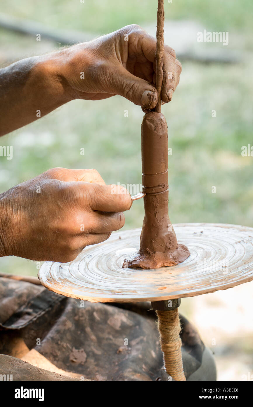 Hands of a artisan creating new clay shape from brown clay. Handicraft