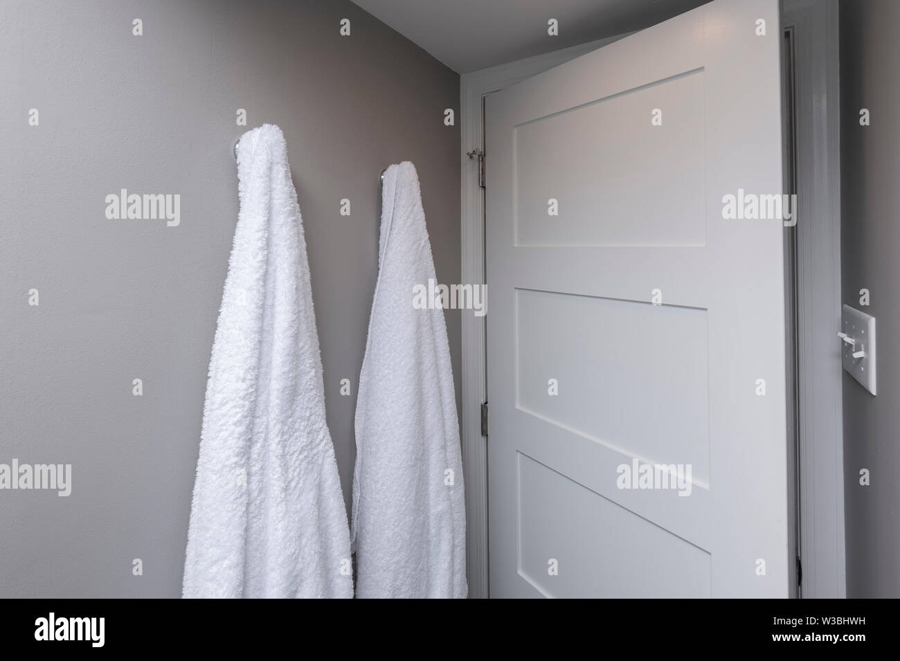 Two Towels Hanging In Simple Plain Bathroom Stock Photo