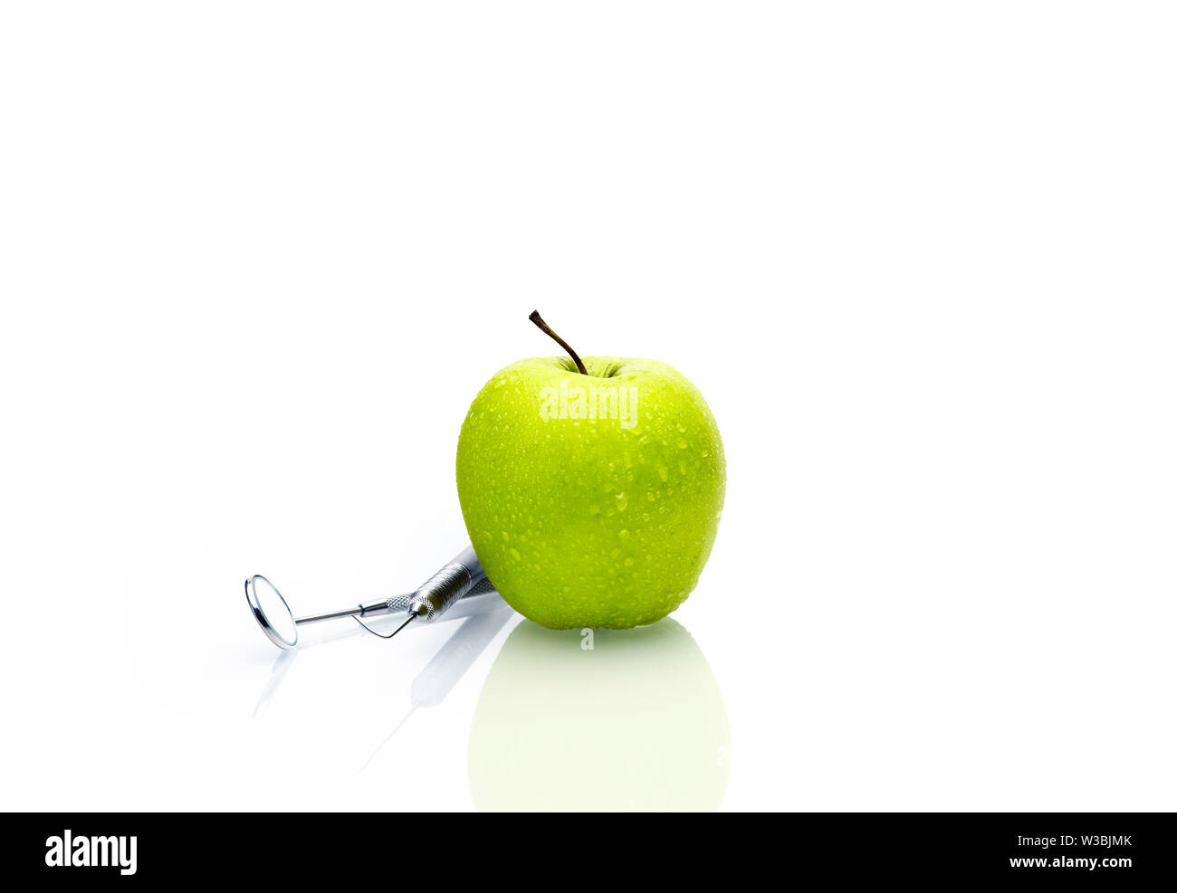Dentist tools professional equipment and green apple on white background. Dental health concept.- Image Stock Photo