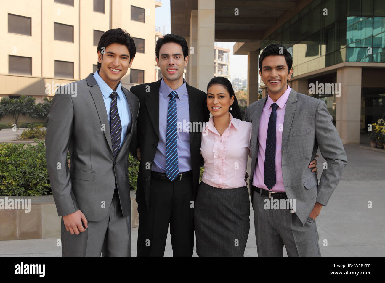 Portrait of four business executives smiling together Stock Photo - Alamy