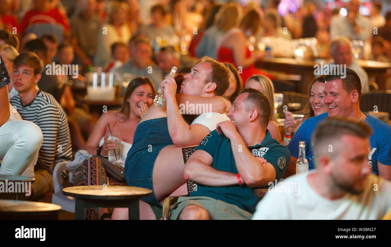 Tourists passing their holidays in Magaluf meet to watch on giant tv screens the Champions League soccer Fin Stock Photo