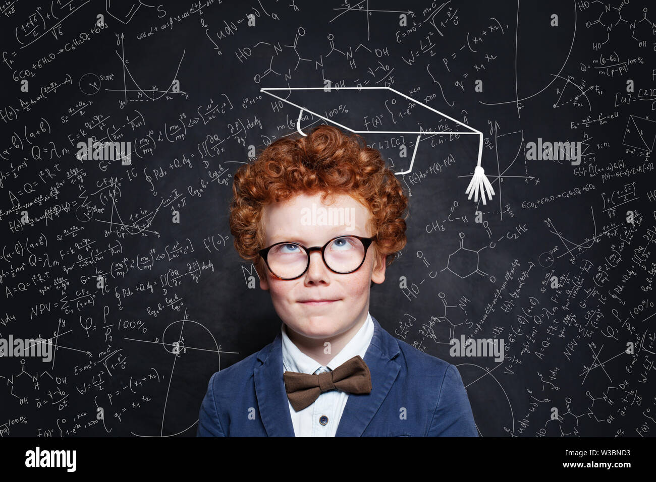 Little child boy thinking on blackboard background. Brainstorming and idea concept Stock Photo