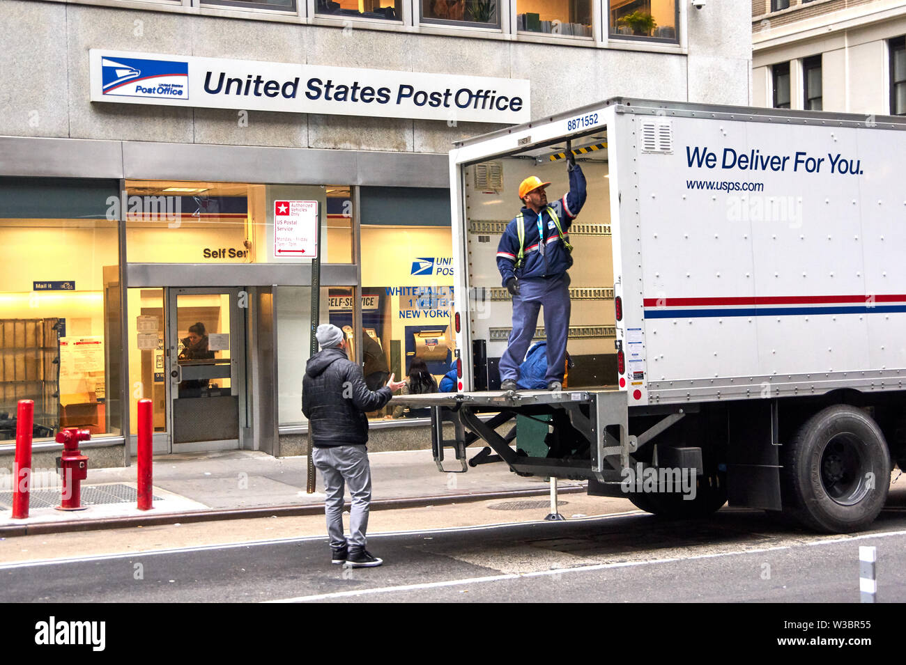 NEW YORK, USA - DECEMBER 14, 2018: USPS postman on a mail delivery truck in New York. USPS is an independent agenc of US federal government responsibl Stock Photo
