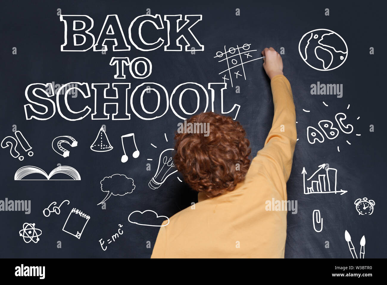 Child school boy playing on chalkboard background. Back to school ...