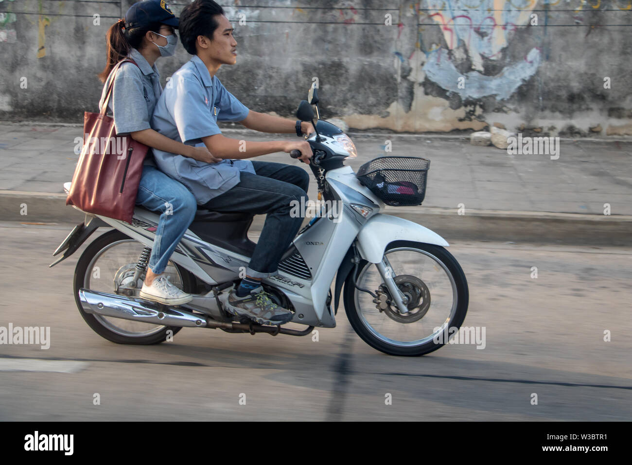 SAMUT PRAKAN, THAILAND, APR 27 2019, Man with woman riding a motorcycle. Couple rides motorcycle in the city streets. Stock Photo