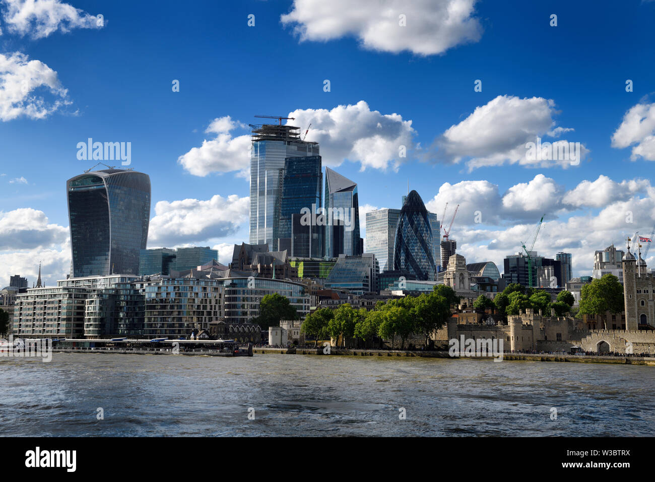 Tower Pier and Tower of London on the River Thames and financial district skyscrapers Walkie Talkie Cheesegrater Scalpel Gherkin London England Stock Photo