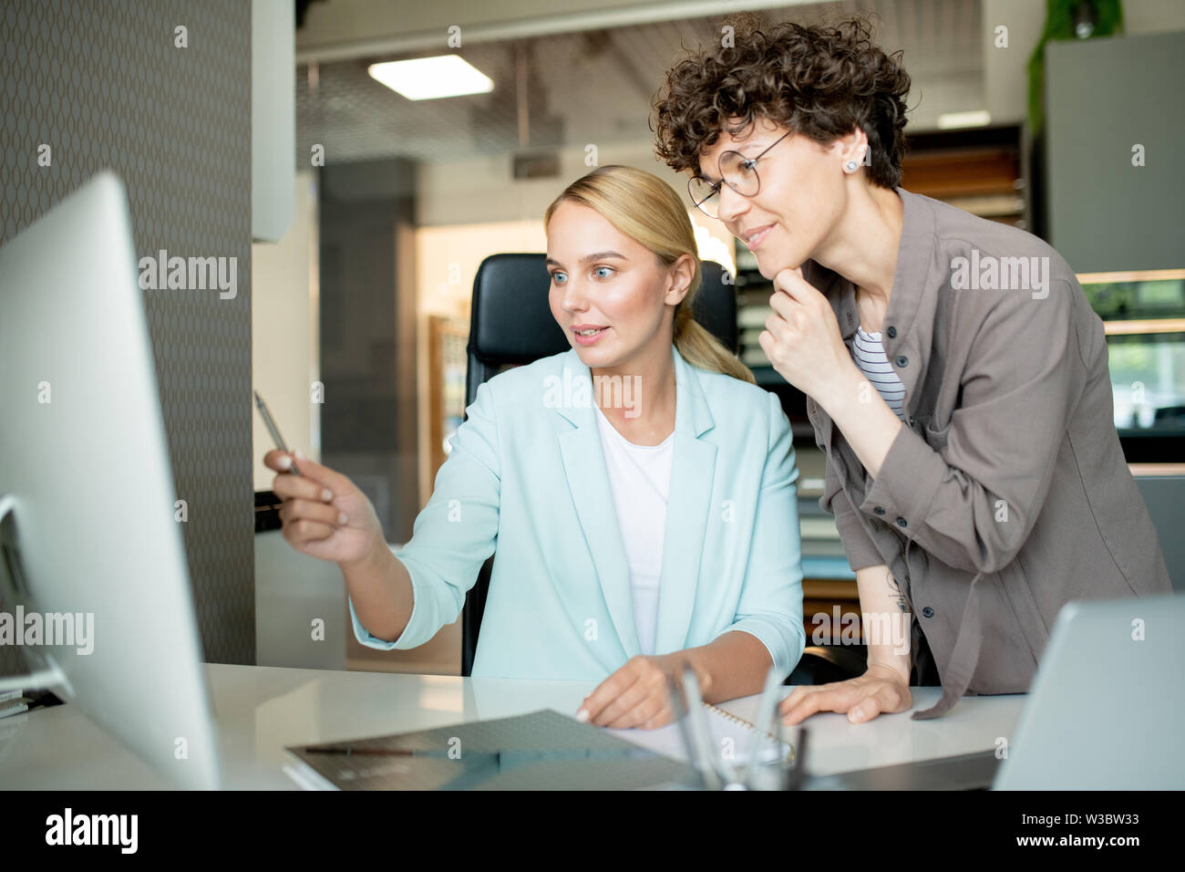 One of young designers explaining stuff on computer screen Stock Photo