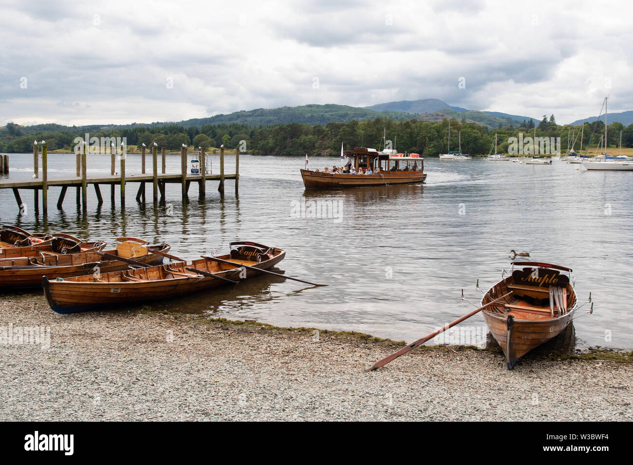Ambleside, Cumbria, UK. 14th July 2019. UK weather - a cloudy day for visitors enjoying a boat trip on Lake Windermere arriving in Ambleside, Cumbria in the Lake District.  Tomorrow is forecast to be a brighter day Credit: Kay Roxby/Alamy Live News Stock Photo