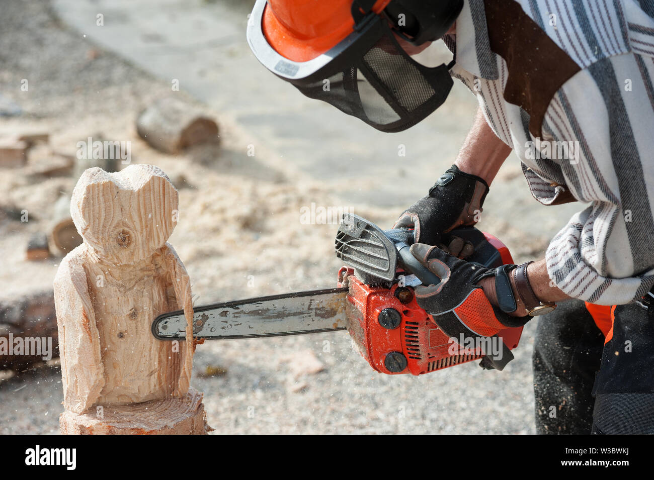 The sculptor carves the wood with the chainsaw Stock Photo