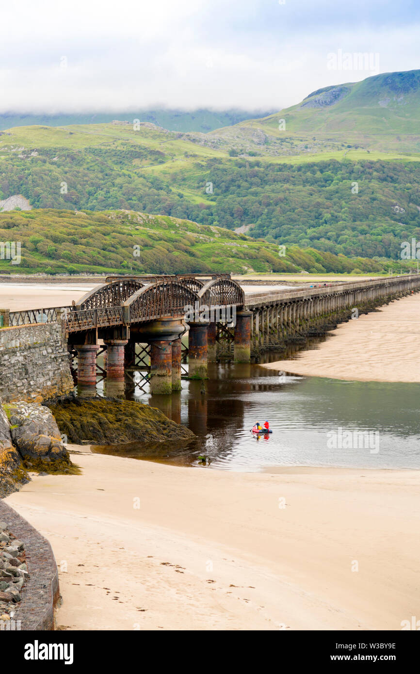 The historic railway bridge across the Mawddach estuary viewed from the harbour in Barmouth, Gwynedd, Wales, UK Stock Photo