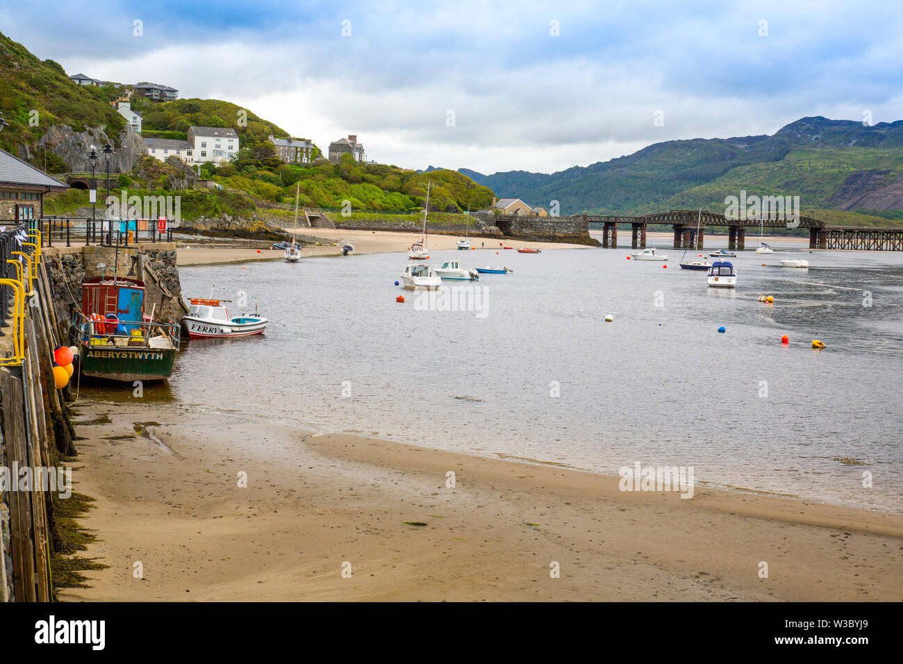 The historic railway bridge across the Mawddach estuary viewed from the harbour in Barmouth, Gwynedd, Wales, UK Stock Photo