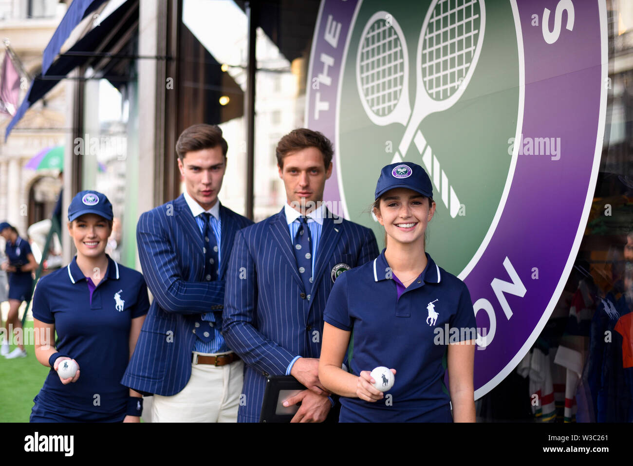 London, UK. 14 July 2019. Promotional staff dress as Wimbledon line judges  and ballgirls outside the Polo Ralph Lauren store during "Summer Streets",  an annual event in Regent Street where the street