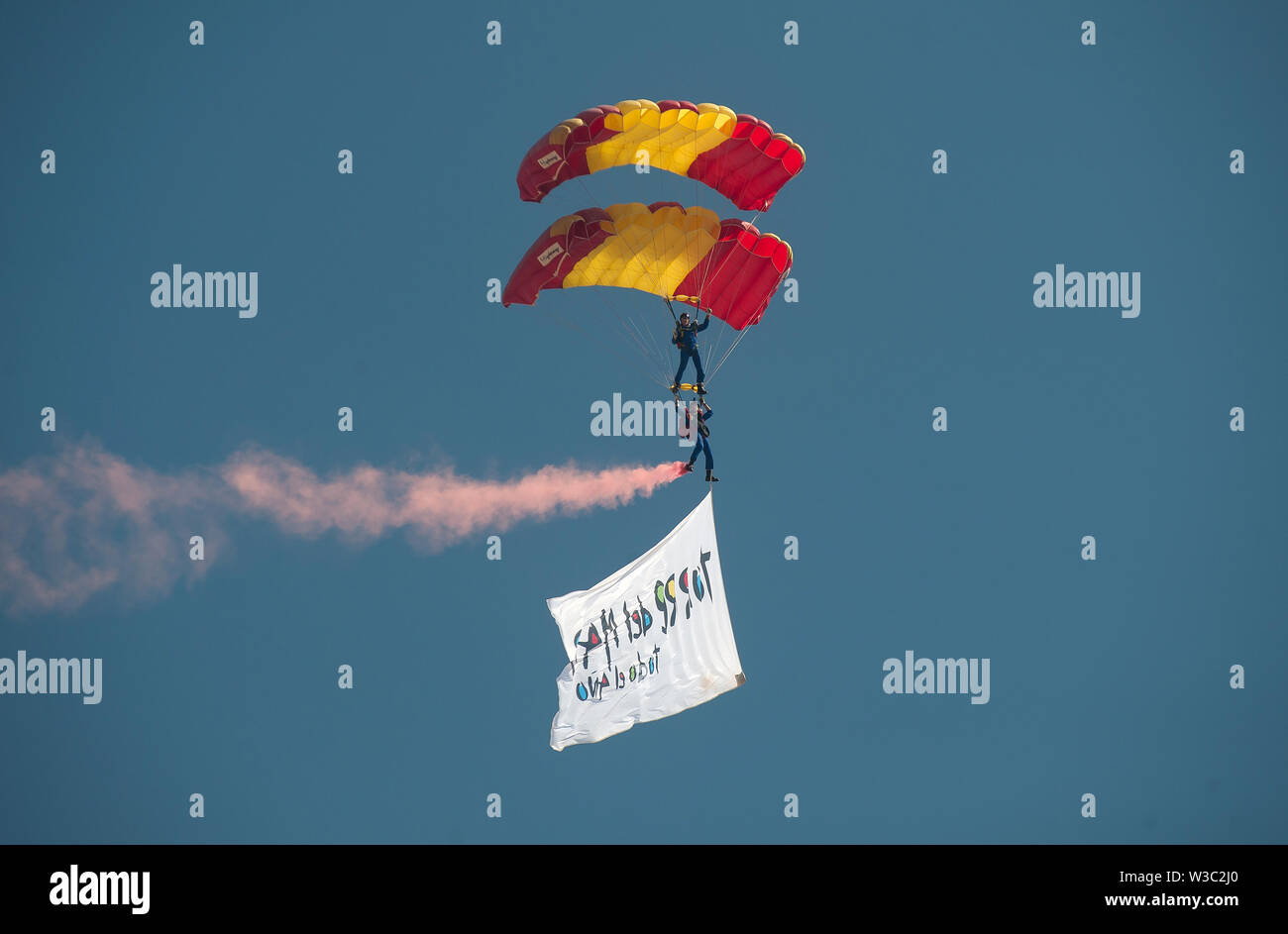 Spanish paratroopers perform in the air during the Festival.The 2019 International Torre del Mar Airshow Festival is being hosted on 12,13 and 14 of July this year, attracting over 300,000 spectators. Members of different patrols perform with exhibitions and acrobatics during the festival. Stock Photo