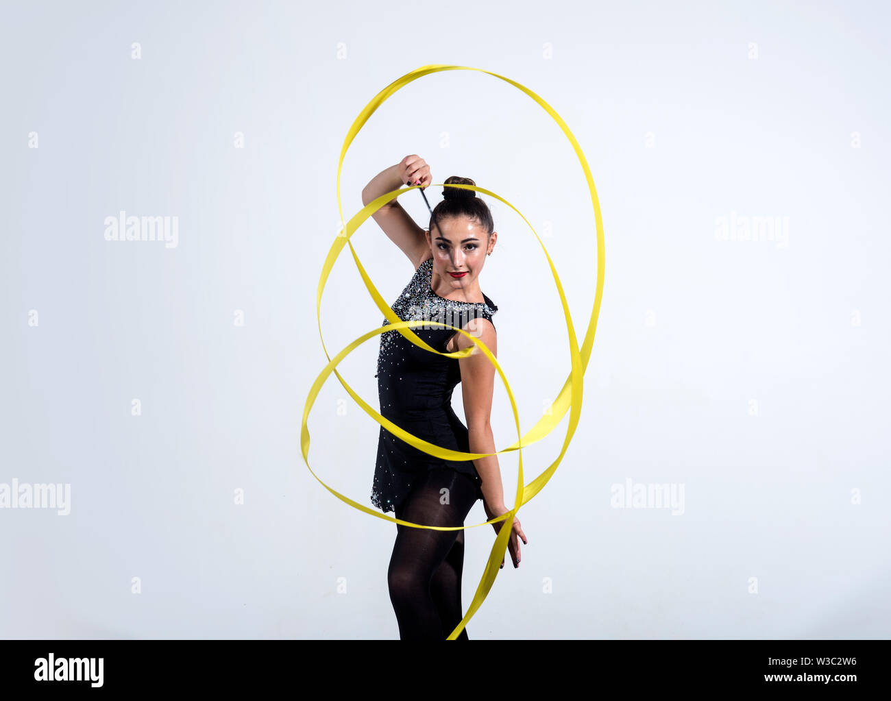 girl train acrobatics with ribbon. girl curl yellow ribbon in rhythmic ...