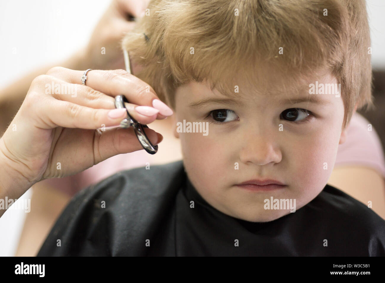 Rough fringe cut. Little child given haircut. Small child in hairdressing  salon. Little boy with blond hair at hairdresser. Cute boys hairstyle. Hair  Stock Photo - Alamy