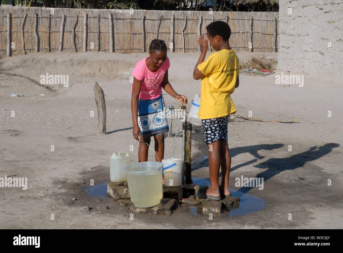 Two girls collecting water, Mwandi, Zambia, Africa. Stock Photo