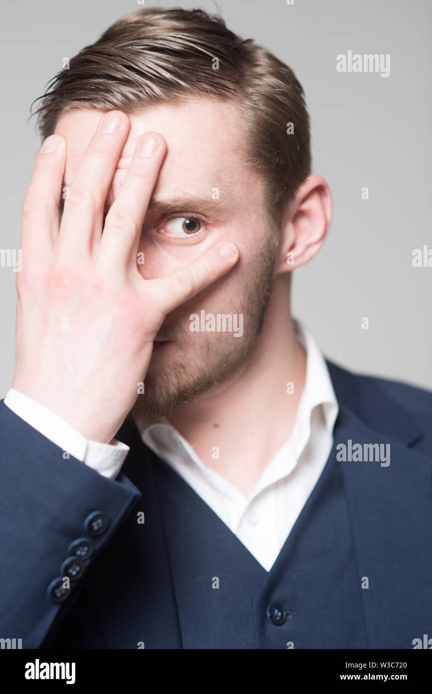 Painful memories. Man serious unhappy hiding face while remembering bad embarrassed events from his past. Memories from unhappy painful childhood Stock Photo