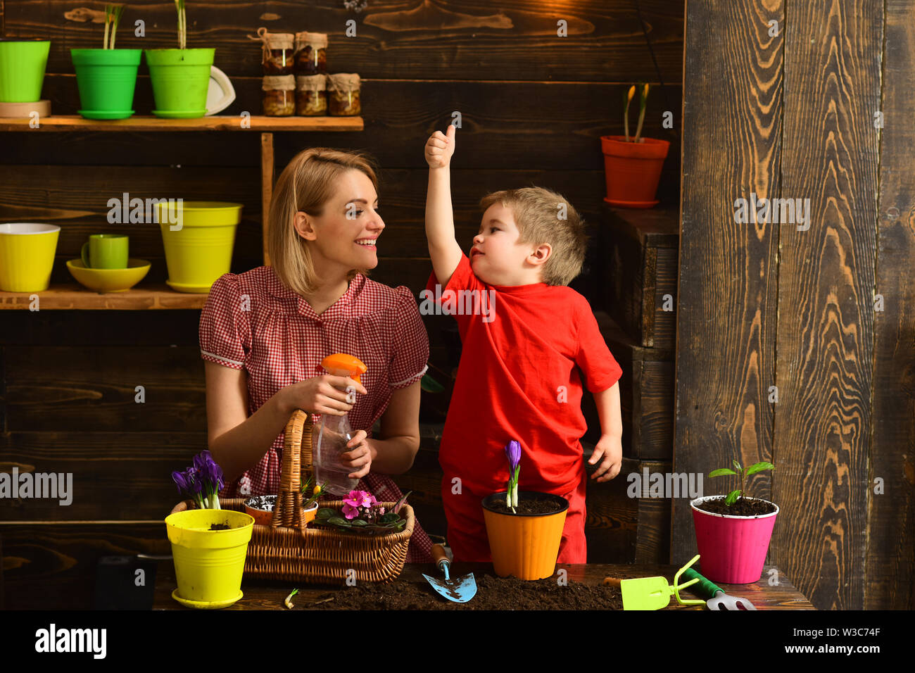 Potting concept. Little child show thumbs up hand to woman in potting