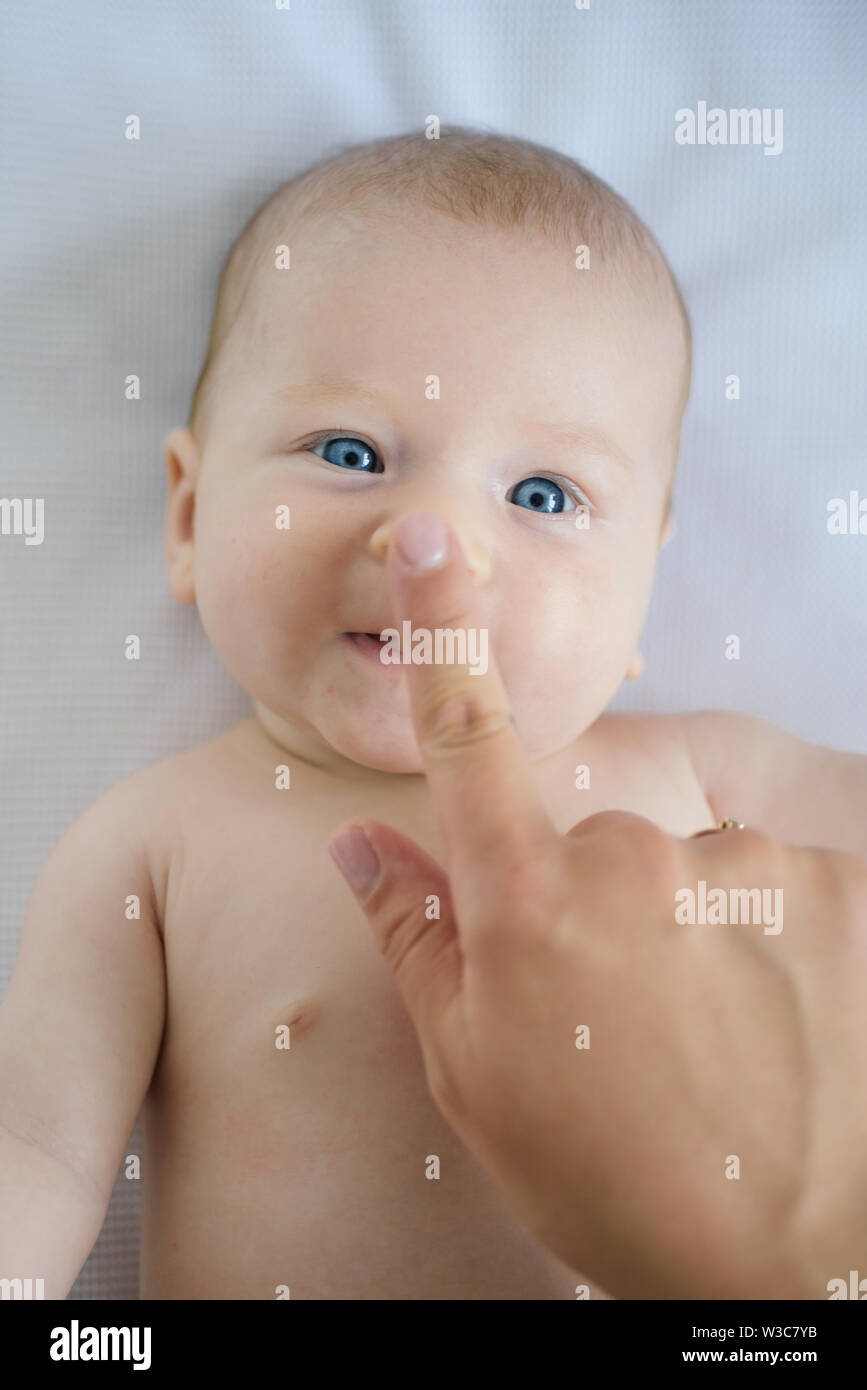 Newborn baby care. Happy newborn enjoys communication pleasure ...