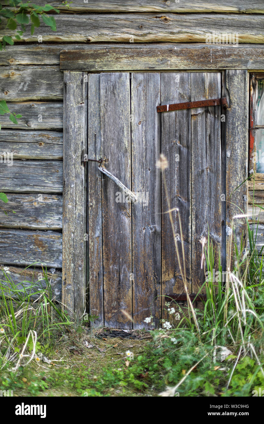 Old weathered door to log sauna at abandoned farmstead in Ylöjärvi, Finland Stock Photo