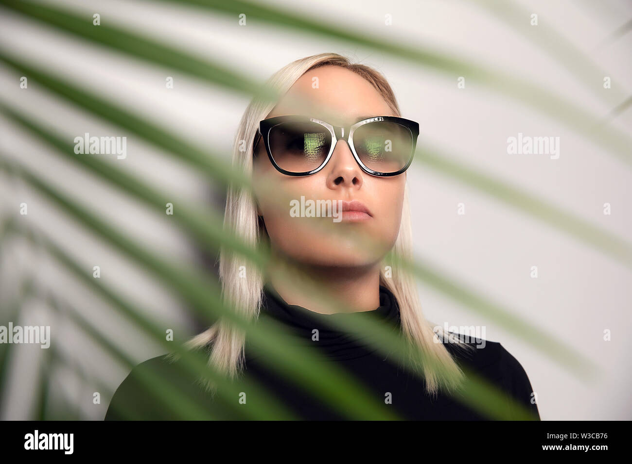Gorgeous woman in sunglasses in tropical environment Stock Photo