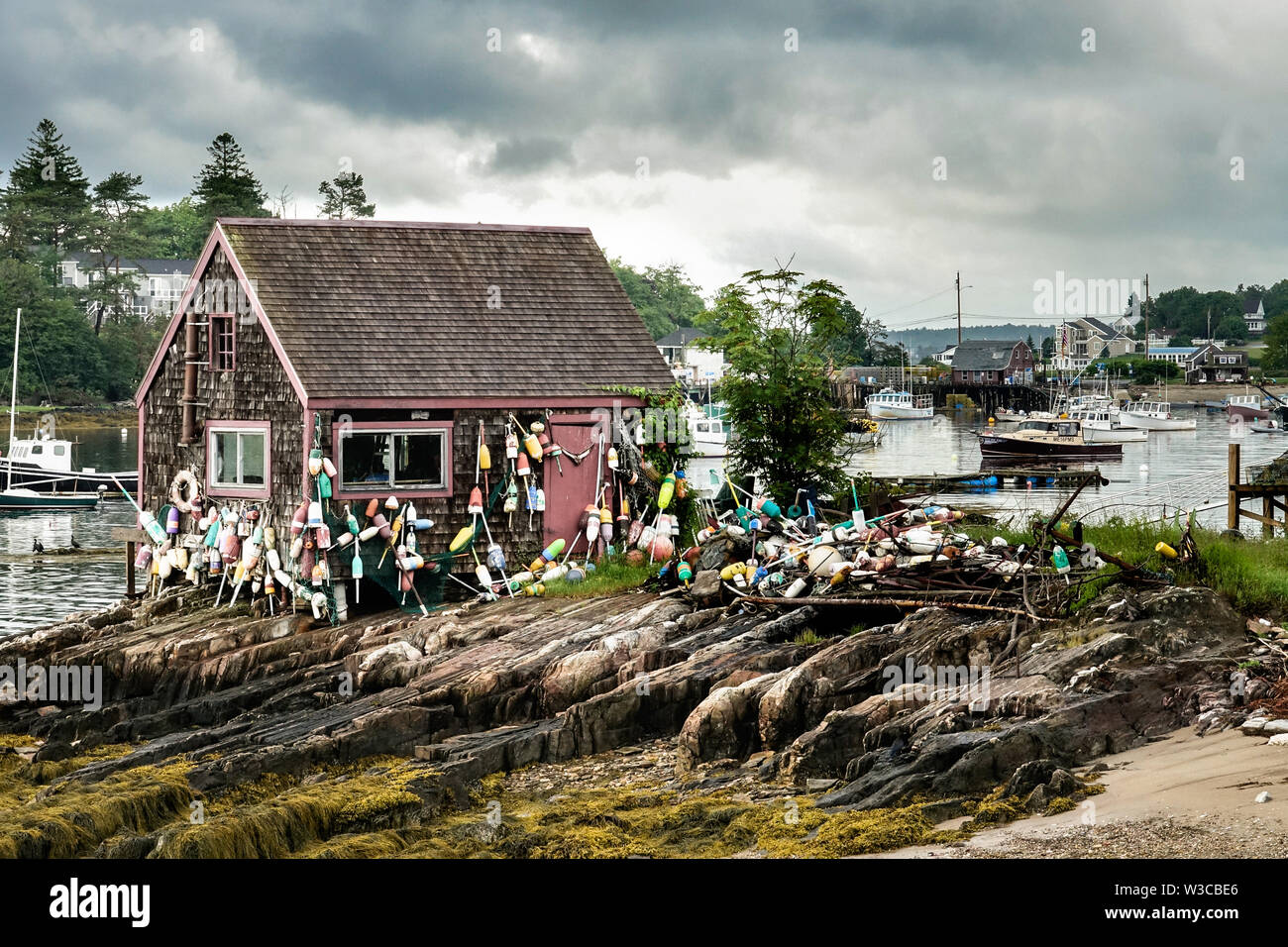 Historic Bailey Fish House covered in lobster buoys along Mackerel Cove on Bailey Island on a stormy summers day in Harpswell, Maine. Stock Photo