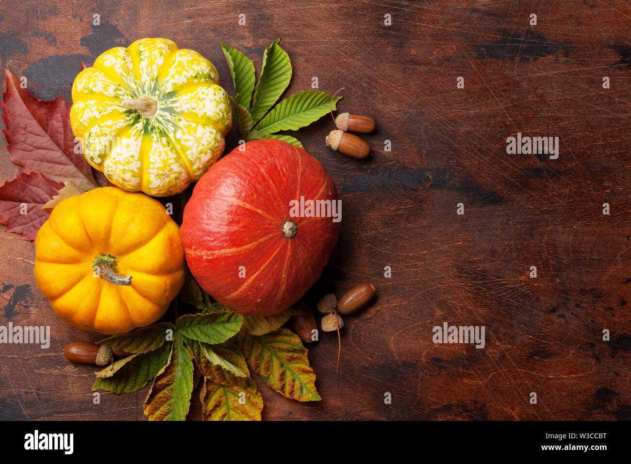 Autumn still life with pumpkins and colorful leaves over wooden ...