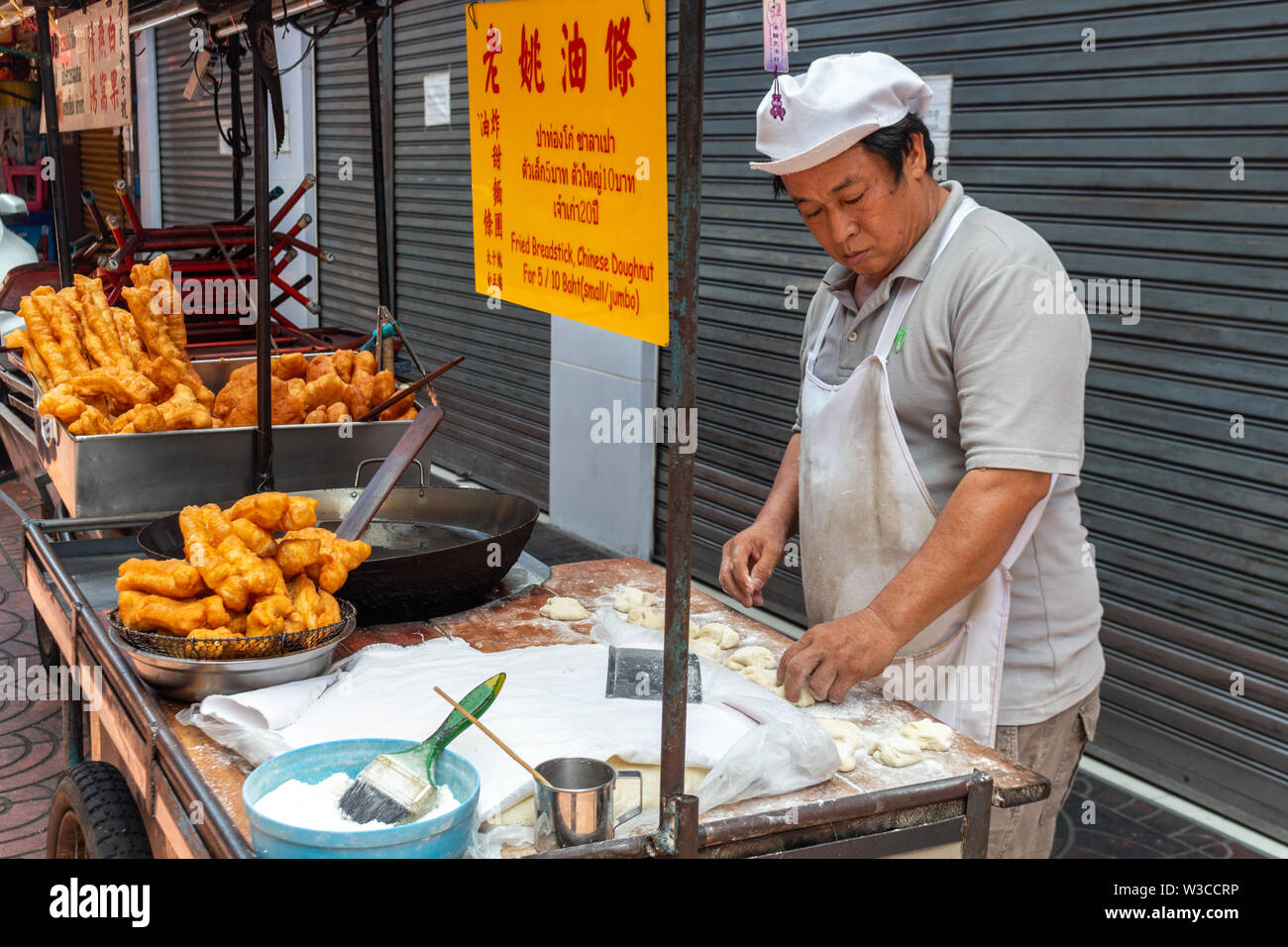 Bangkok, Thailand - April 14, 2019: Chinese man cooking fried street food in Bangkok's chinatown district Stock Photo