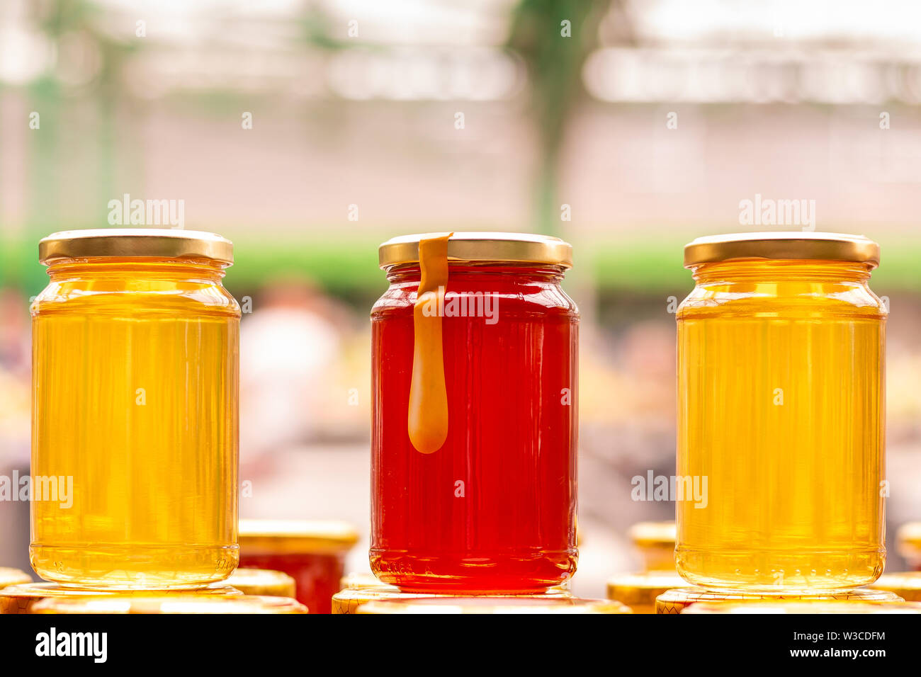 Three glass honey jars on the marketplace counter in Belgrade. Close up