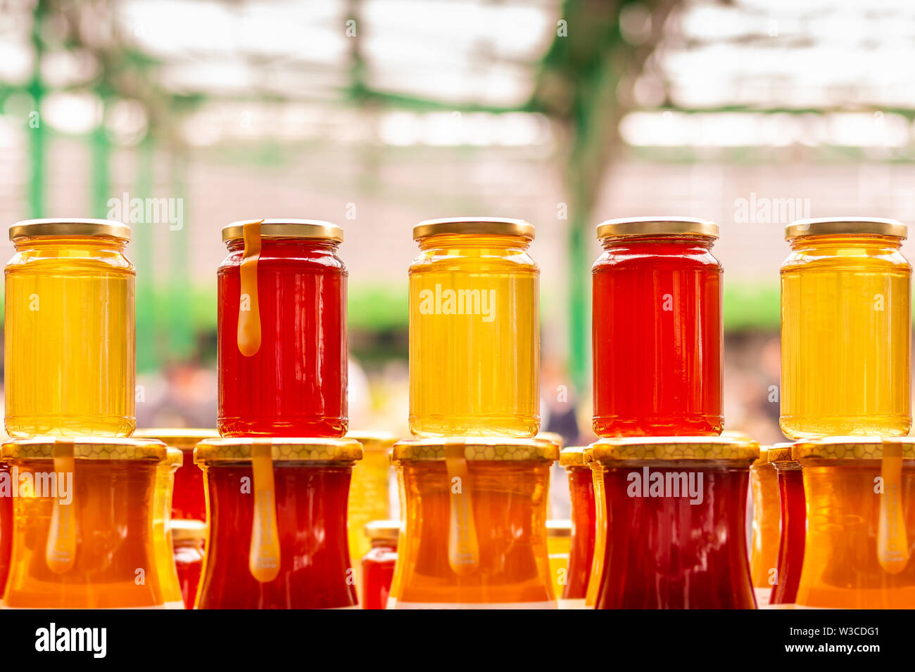 Pile of glass honey jars on the marketplace counter in Belgrade. Close