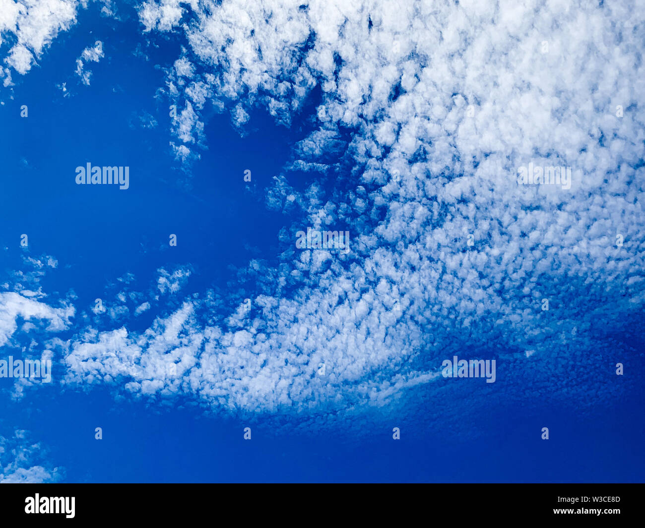 Cirrocumulus clouds are small rounded puffs that usually appear in long rows high in the sky. Cirrocumulus are usually white Stock Photo