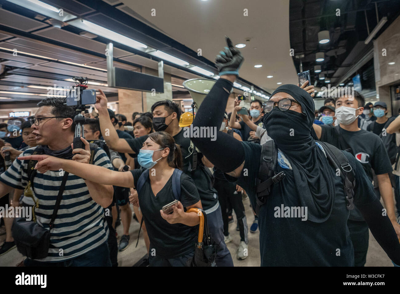 Demonstrators chanting slogans to the police as the police officers attempt to arrest protesters. Thousands of pro democracy demonstrators took to the street once again in a new wave of anti government demonstrations which sparked by the extradition bill that the Hong Kong government was trying to push forward in June 2019.Police has made at least 30 arrests as protesters clashed with the riot police in the evening. Stock Photo