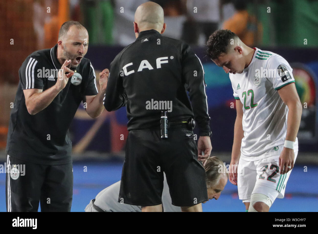 Cairo, Egypt. 14th July, 2019. Algeria's national team coach Djamel Belmadi (L) speaks with the referee during the 2019 Africa Cup of Nations semi-final soccer match between Algeria and Nigeria at the Cairo International Stadium. Credit: Oliver Weiken/dpa/Alamy Live News Stock Photo
