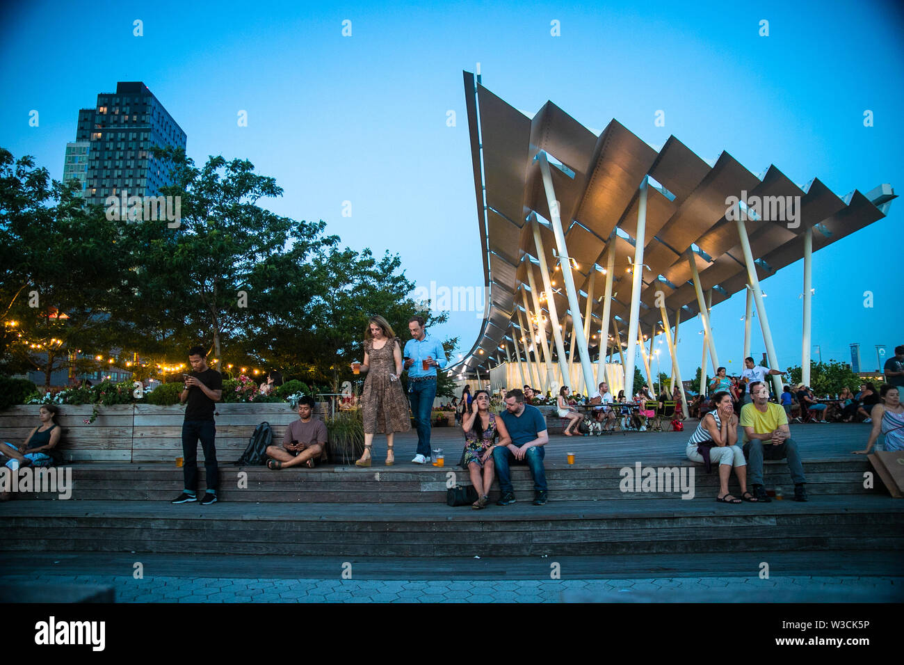LONG ISLAND CITY, NEW YORK - JULY 13, 2019:  View at Gantry Plaza State Park on a summer evening with people visible. Stock Photo
