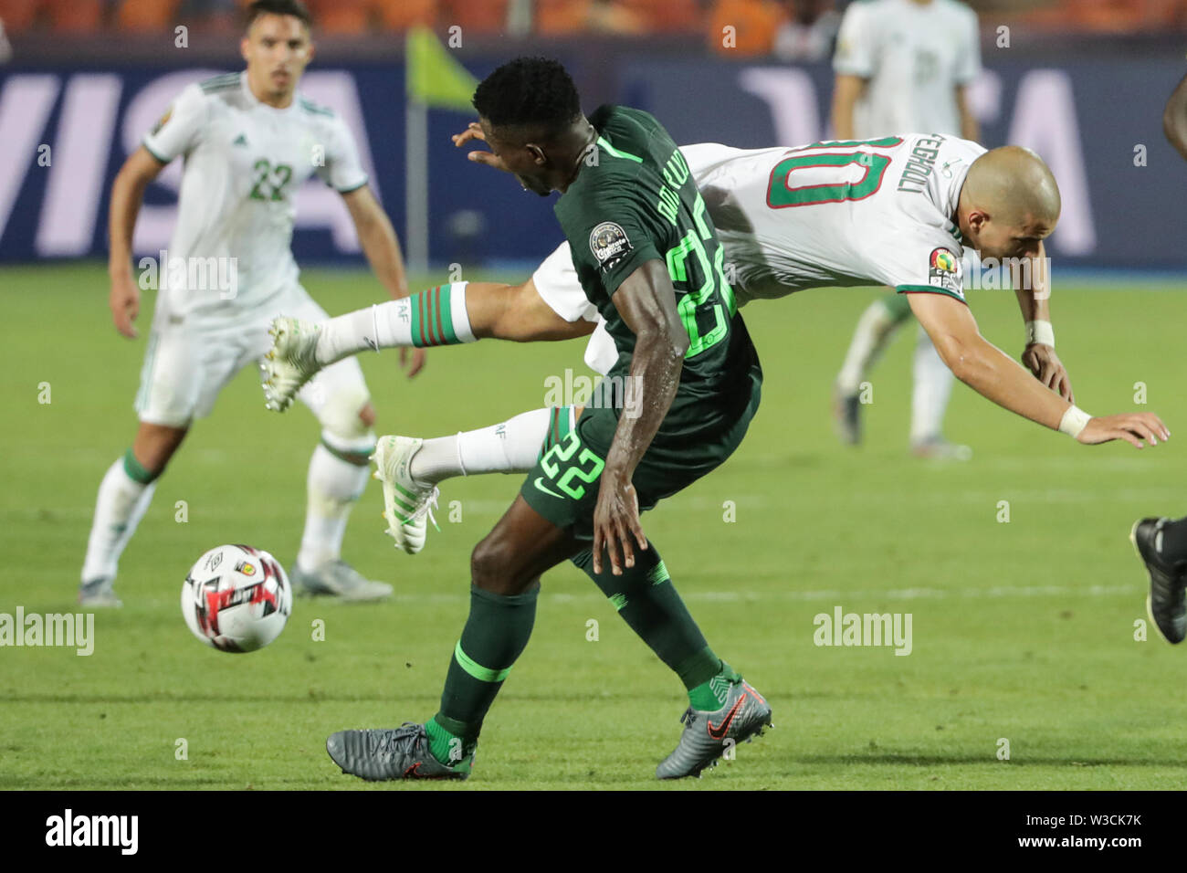Cairo, Egypt. 14th July, 2019. Algeria's Sofiane Feghouli (top) and Nigeria's Kenneth Omeruo during the 2019 Africa Cup of Nations semi-final soccer match between Algeria and Nigeria at the Cairo International Stadium. Credit: Oliver Weiken/dpa/Alamy Live News Stock Photo