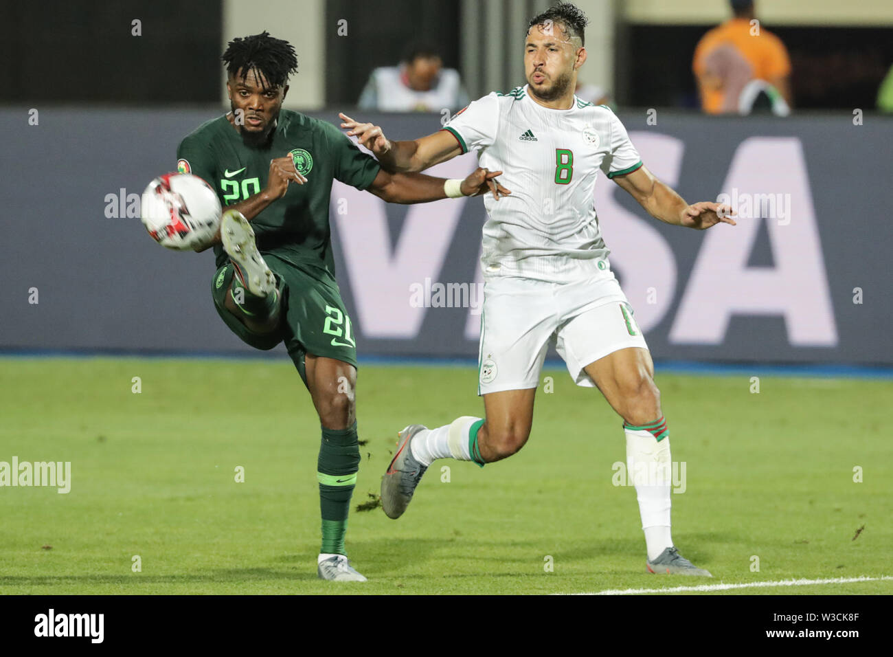 Cairo, Egypt. 14th July, 2019. Nigeria's Chidozie Awaziem (L) and Algeria's Youcef Belaili during the 2019 Africa Cup of Nations semi-final soccer match between Algeria and Nigeria at the Cairo International Stadium. Credit: Oliver Weiken/dpa/Alamy Live News Stock Photo