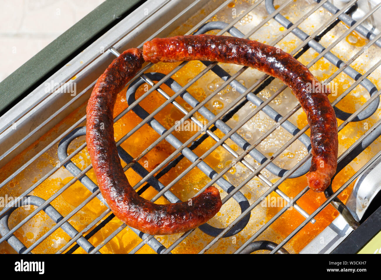 Grilled merguez on the grid of an electric barbecue Stock Photo