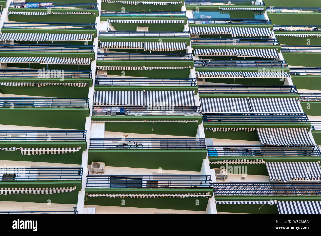 Looking up a high rise apartment building with patios and air