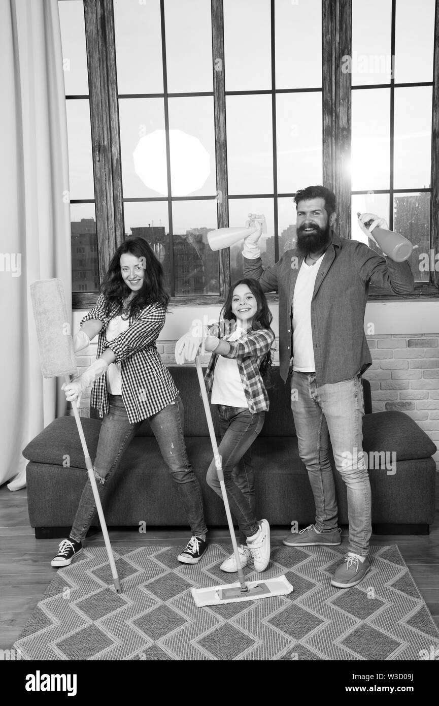 Family mom dad and daughter with cleaning supplies at living room. We