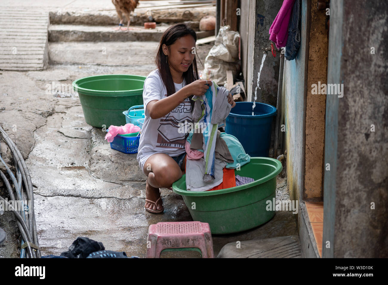 https://c8.alamy.com/comp/W3D10K/a-young-girl-washes-clothes-by-hand-within-a-local-poor-communitycebu-cityphilippines-W3D10K.jpg