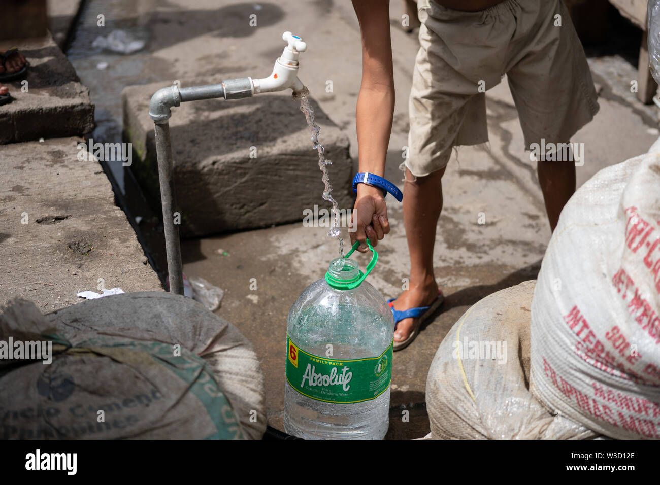 https://c8.alamy.com/comp/W3D12E/a-young-boy-filling-a-plastic-water-container-from-a-standing-water-pipe-within-a-poor-communitycebu-cityphilippines-W3D12E.jpg