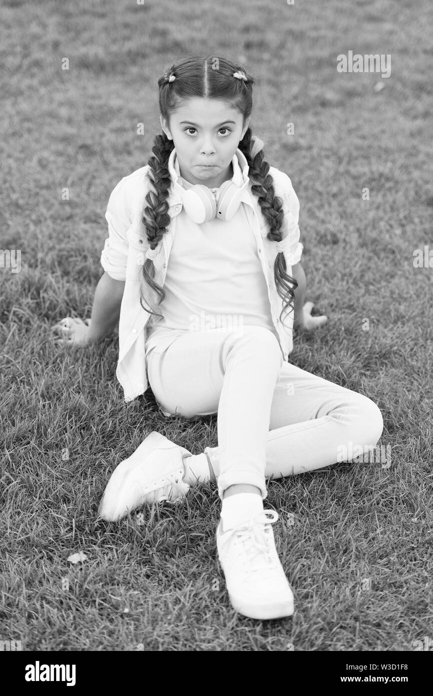 What makes child happy. Girl braids hairstyle and modern headphones