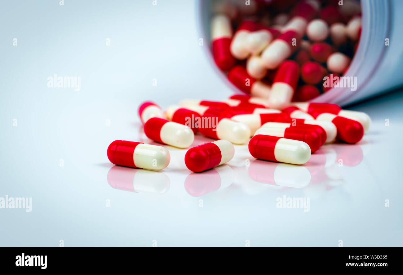 Red White Capsule Pills On White Table On Blurred Background Of