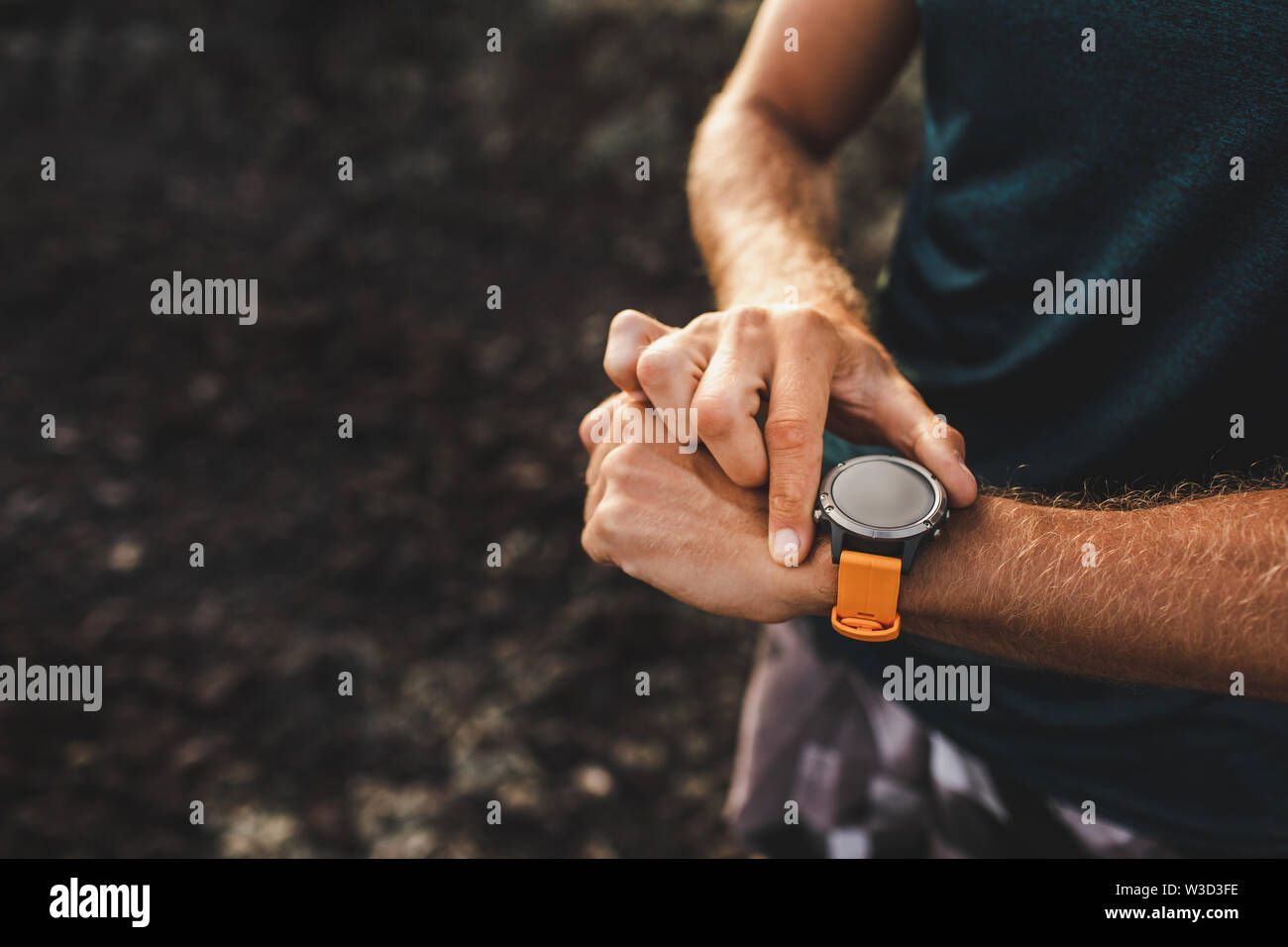 Young athletic man using fitness tracker or smart watch before run ...